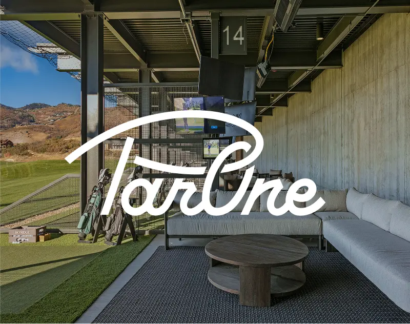 Covered golf hitting bay lounge area at ParOne with seating and mountain views