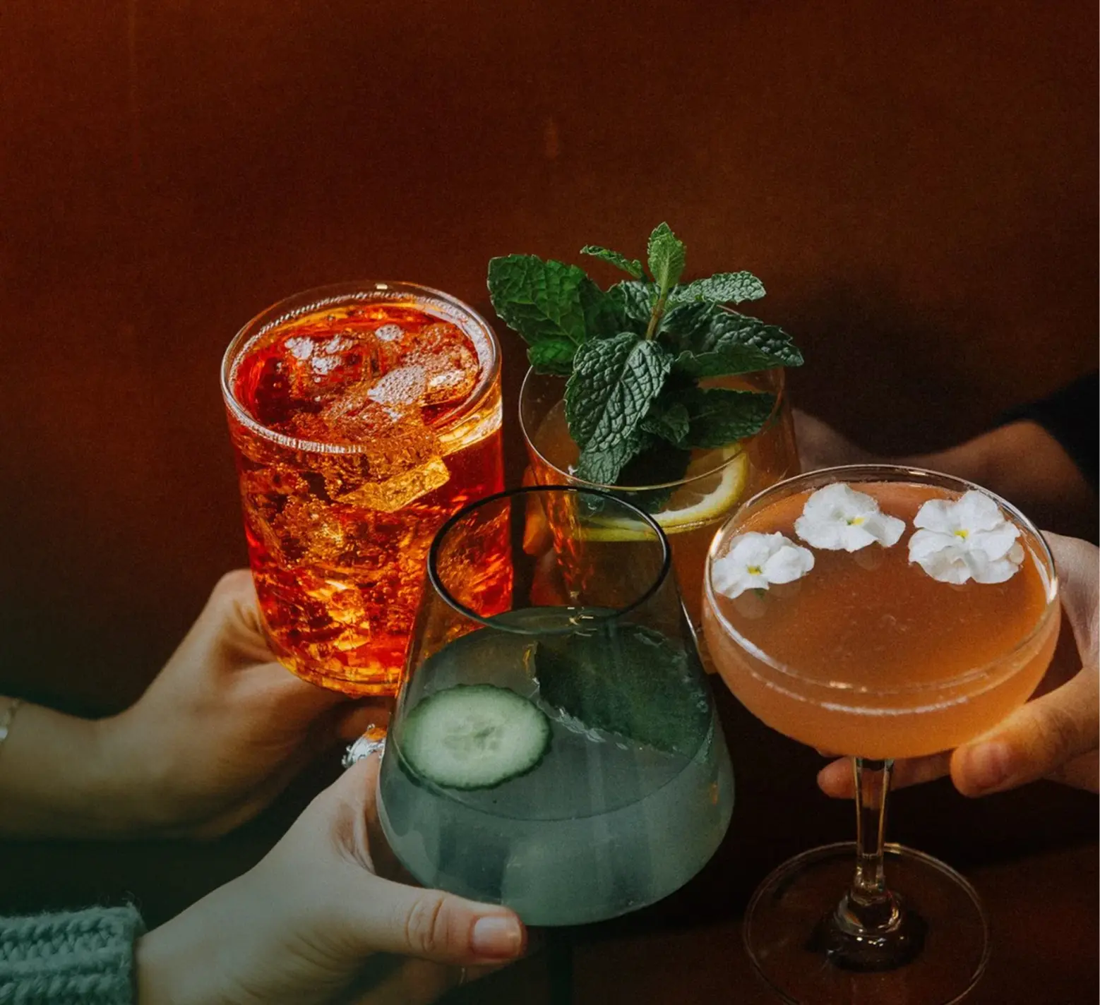Three cocktails on a table during a social gathering inside a lounge