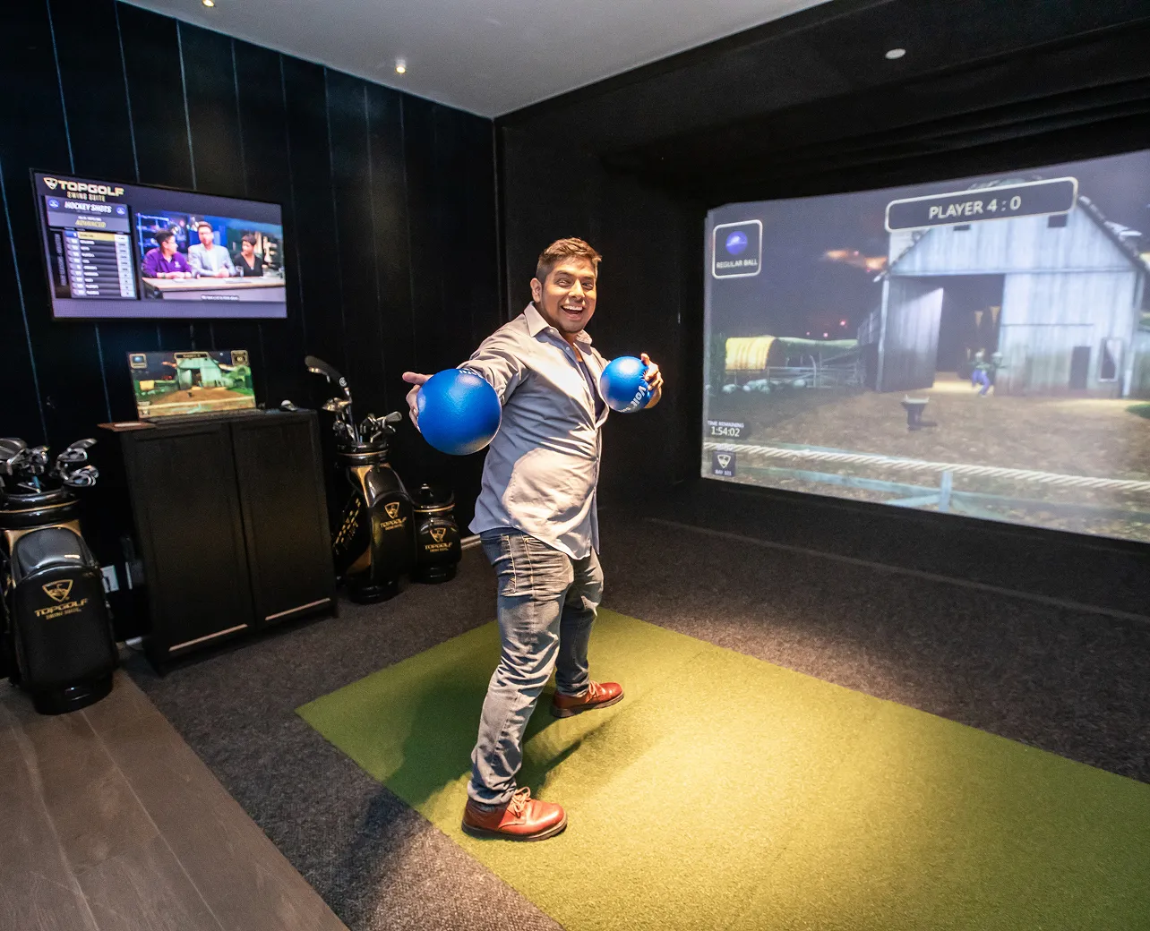 Person playing an interactive sports game inside an indoor simulator room